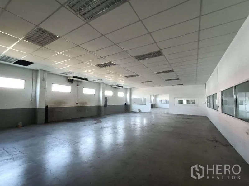 Warehouse for rent or sale in Pathum Thani - Spacious warehouse or production hall with high ceiling and ventilation windows.