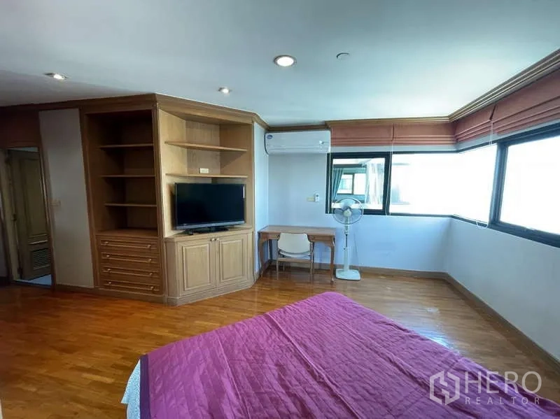 Condominium for rent - Bedroom view with built-in TV cabinet, open shelves, study desk and wraparound windows.
