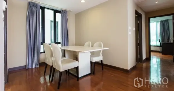 Condominium for rent in Sathon, Bangkok - Cozy dining nook with a four-seat table beside a window and hallway in a Sathon condo.