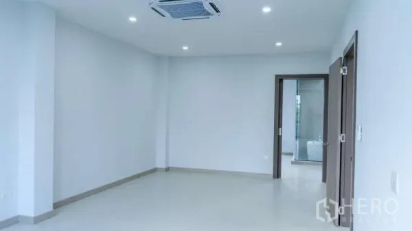 独立式住宅 出租或出售在Suan Luang, Bangkok - 明亮空旷的起居区，筒灯与嵌入式空调，白墙及通往浴室的门