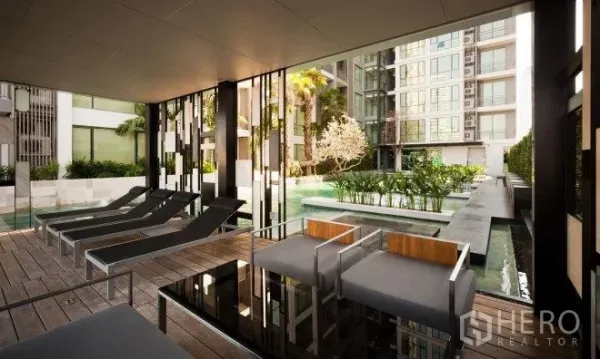 公寓 出租在Watthana, Bangkok - 公寓度假式泳池，躺椅、遮蔽休息区与景观庭院。