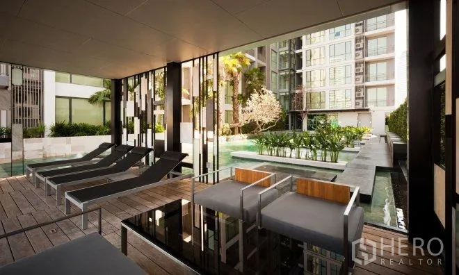 公寓 出租在Watthana, Bangkok - 公寓度假式泳池，躺椅、遮蔽休息区与景观庭院。