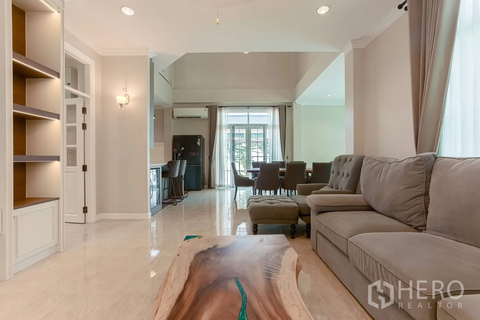บ้านเดี่ยว for rent in Bang Na, Bangkok - มุมมองห้องนั่งเล่นอบอุ่น โต๊ะกลางไม้ลายสวย และโซฟาสีเทานุ่ม