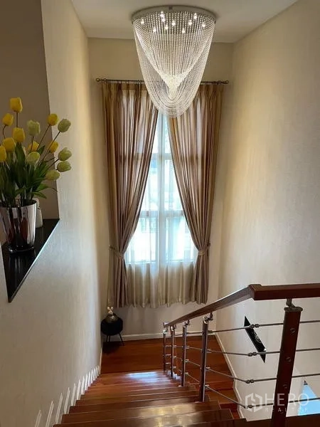 Detached House for sale in Lat Krabang, Bangkok - Stairwell with stainless handrail, chandelier and a tall window for natural light.