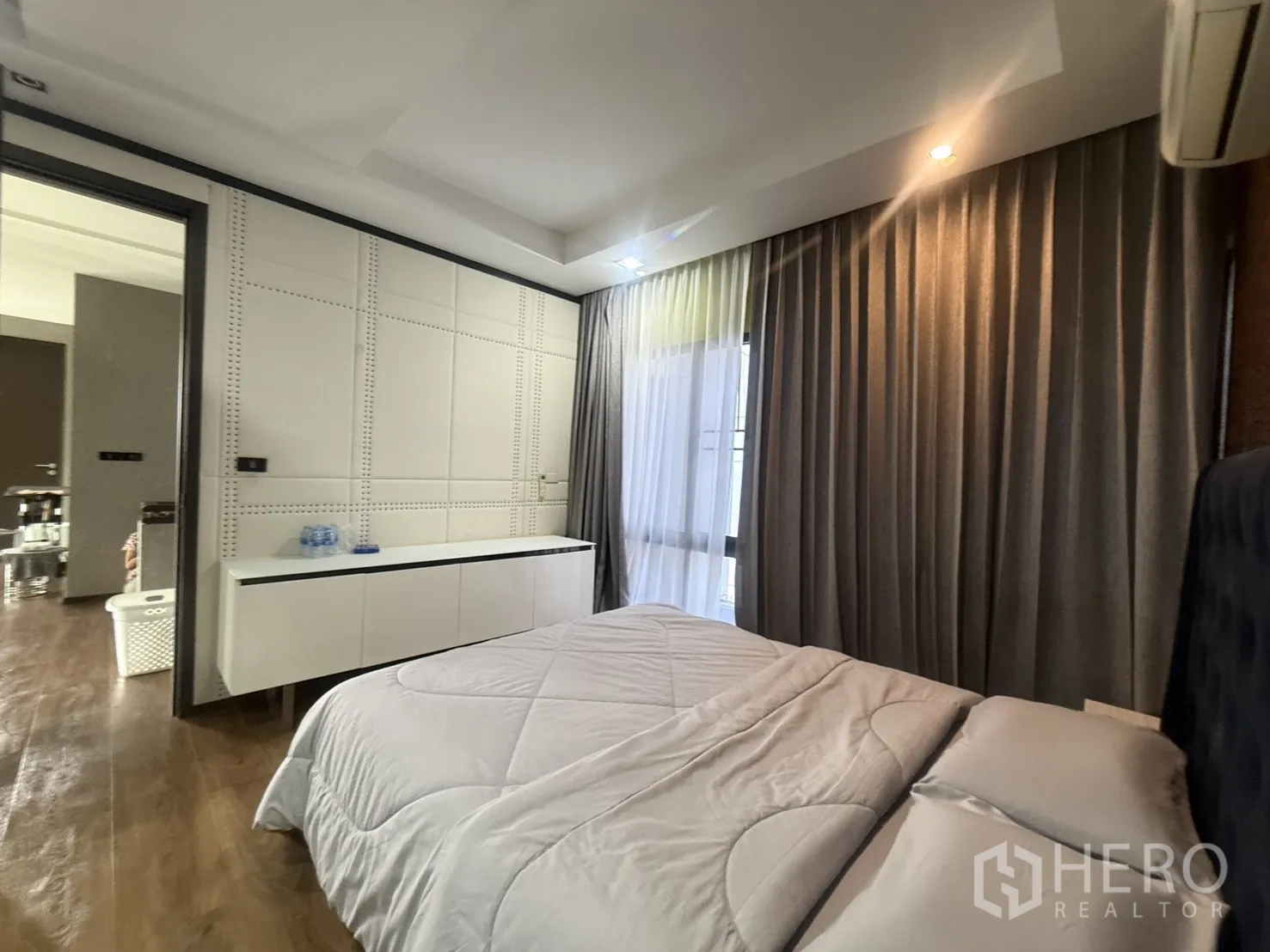 Detached House for rent in Bang Kapi, Bangkok - Bedroom corner with paneled wall, long cabinet, and sheer curtains.