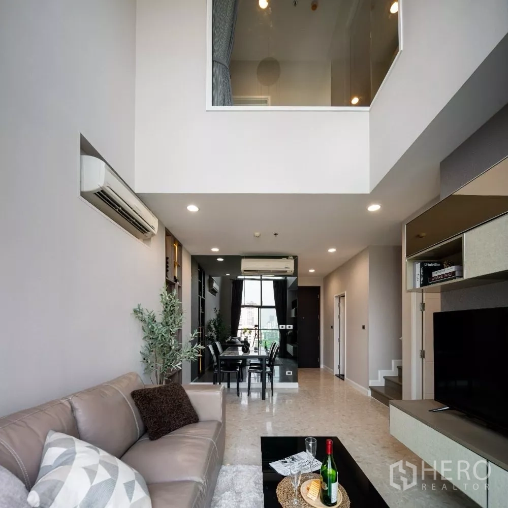 Condominium for rent or sale in Khlong Toei, Bangkok - Spacious loft-style living area facing the dining zone and tall window.