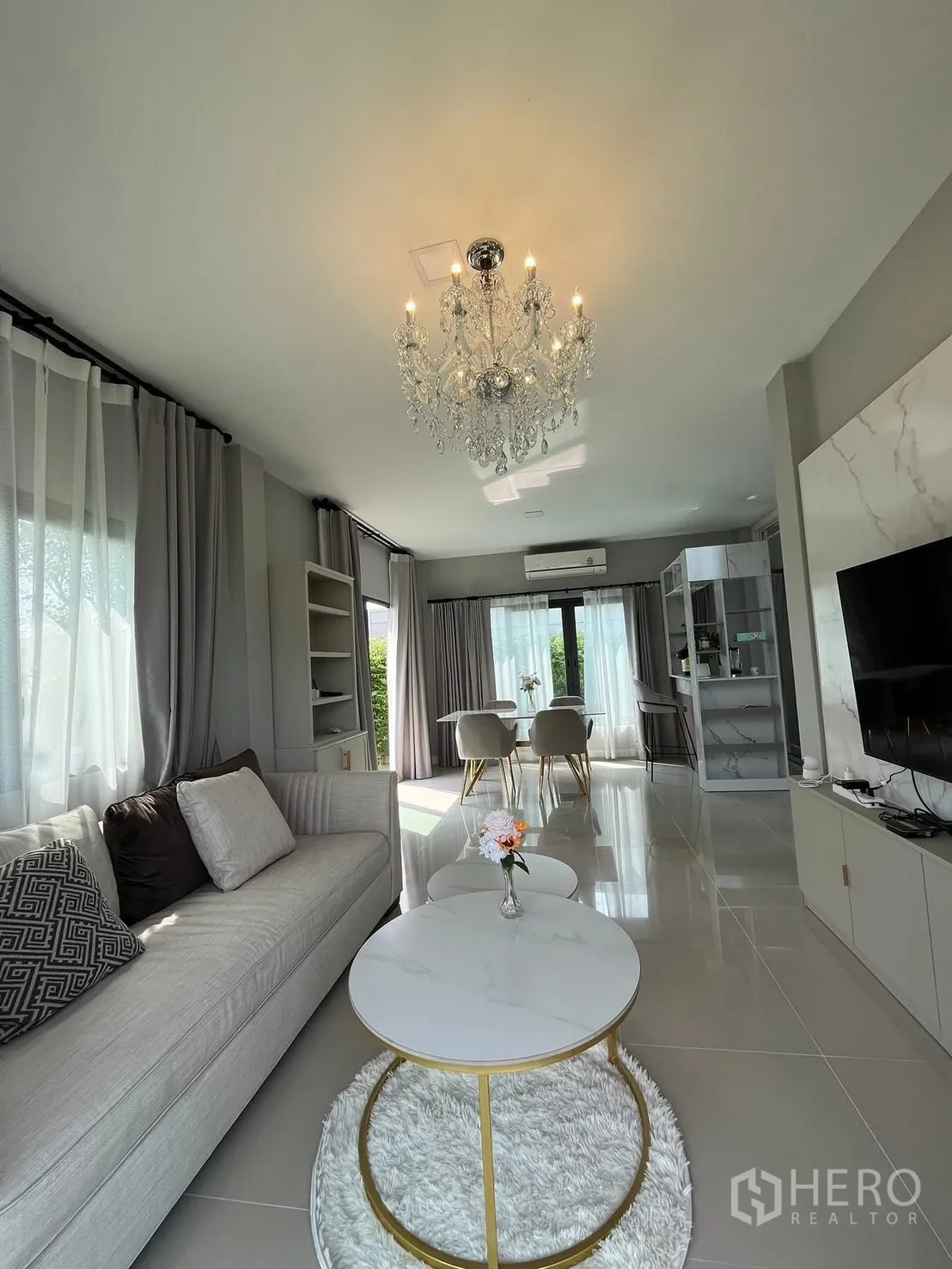 บ้าน for rent in Bang Phli, Samut Prakan - โถงรับแขกเชื่อมทานอาหาร โคมระย้า โซฟา ผนังทีวี และหน้าต่างบานใหญ่