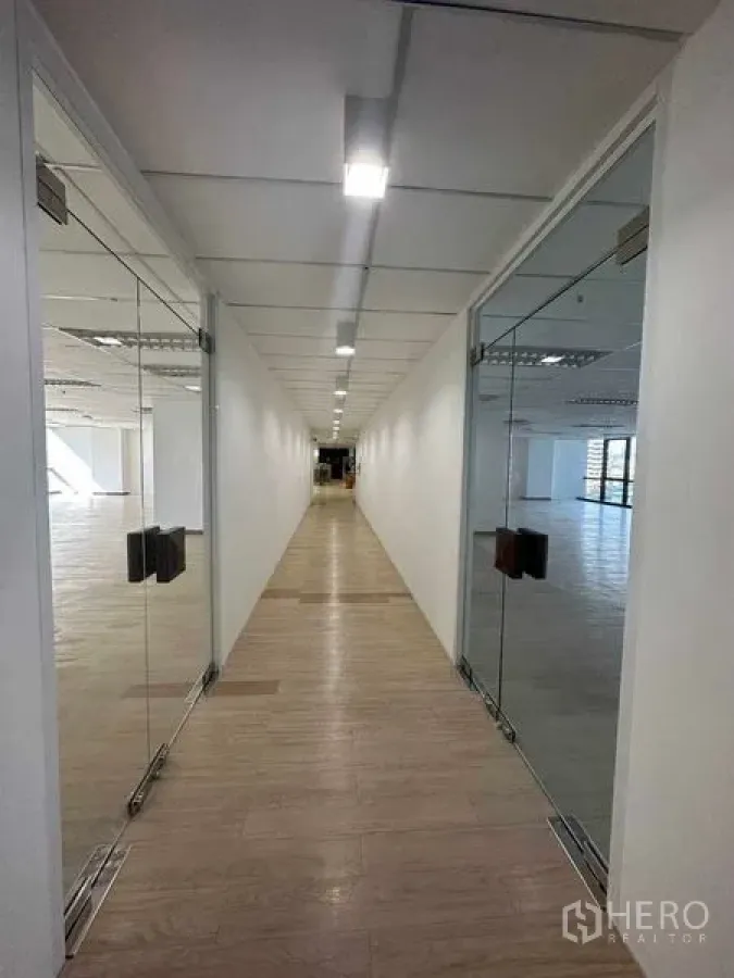 สำนักงาน ให้เช่าในWatthana, Bangkok - โถงทางเดินสว่างมีประตูกระจกหน้าออฟฟิศทั้งสองด้าน พื้นลายไม้ และไฟเพดาน