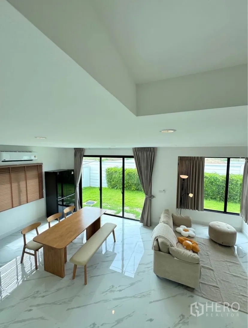 Detached House for rent in Samut Prakan - Overhead view of open-plan living and dining opening to a green backyard.