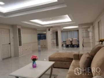 Apartment for rent in Watthana, Bangkok - Open-plan lounge and dining space with ceiling lighting, sofa, coffee table and dining set.