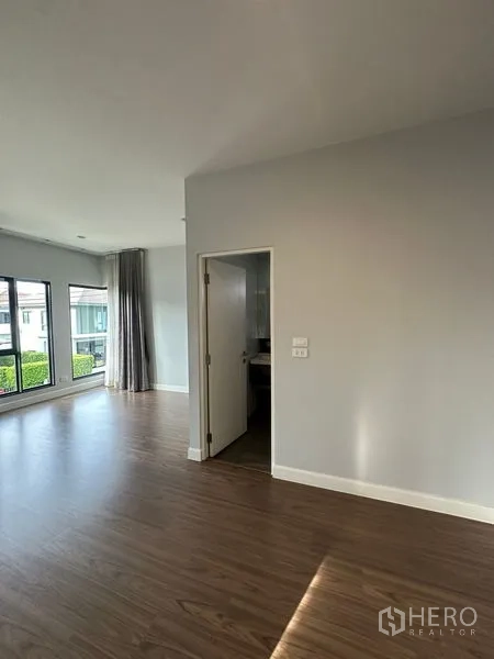 Detached House for rent or sale in Lam Luk Ka, Pathum Thani - Master suite viewed from another angle showing doorway to private bathroom and wide windows.