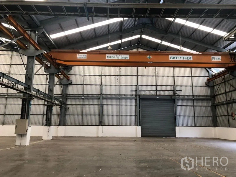Factory for rent in Khlong Luang, Pathum Thani - Factory interior featuring a 10-ton overhead gantry crane and large roller shutter door.