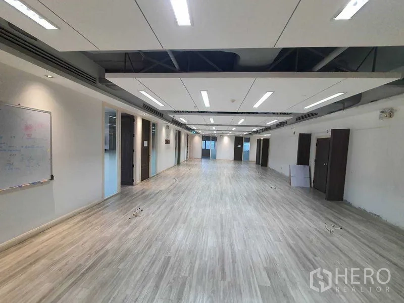 Office Space for rent in Watthana, Bangkok - Large open office floor plate with bright ceiling panels and private rooms.