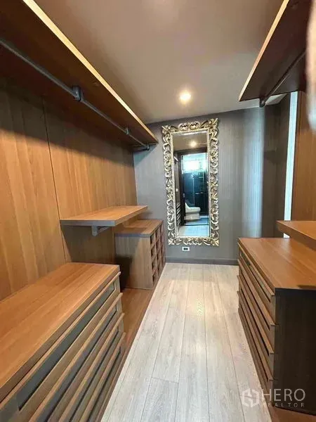 公寓 出售在Watthana, Bangkok - 宽敞步入式衣帽间，温润木质柜体与精致雕花镜。