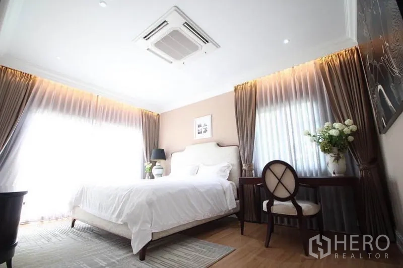 独立式住宅 出租或出售在Lat Phrao, Bangkok - 主卧明亮，配大床、书桌与吊顶式空调。