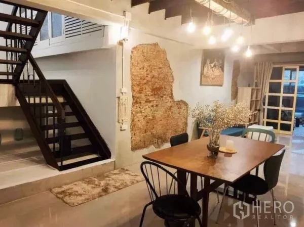 บ้าน ให้เช่าในPathum Wan, Bangkok - พื้นที่รับประทานอาหาร โต๊ะไม้ ผนังอิฐโชว์ และบันไดโลหะ ใต้ไฟห้อย