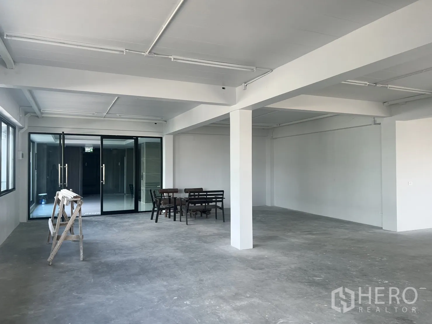 办公空间 出租在Lat Krabang, Bangkok - 未配家具的办公室，推拉玻璃入口与少量桌椅。