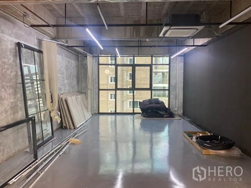 办公空间 出租在Khlong Toei, Bangkok - 长方形工作室空间，抛光地坪、吊装照明与落地窗。