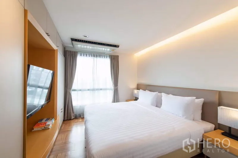 Apartment for rent - Master bedroom with king-size bed, built-in TV niche, soft cove lighting and curtained window.