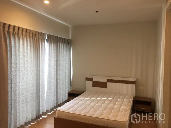 Condominium for rent in Phaya Thai, Bangkok - Bright bedroom with queen bed, bedside tables and full-length curtains.