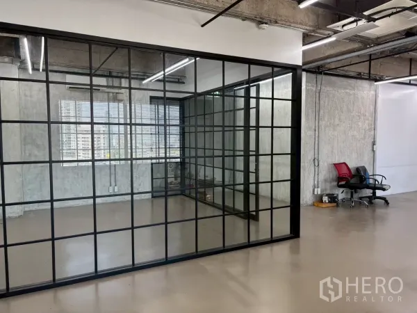办公空间 出租在Watthana, Bangkok - 黑框落地玻璃会议室，旁有百叶窗与城市景观，工业风格。