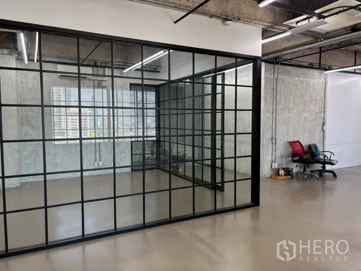 办公空间 出租在Watthana, Bangkok - 黑框落地玻璃会议室，旁有百叶窗与城市景观，工业风格。