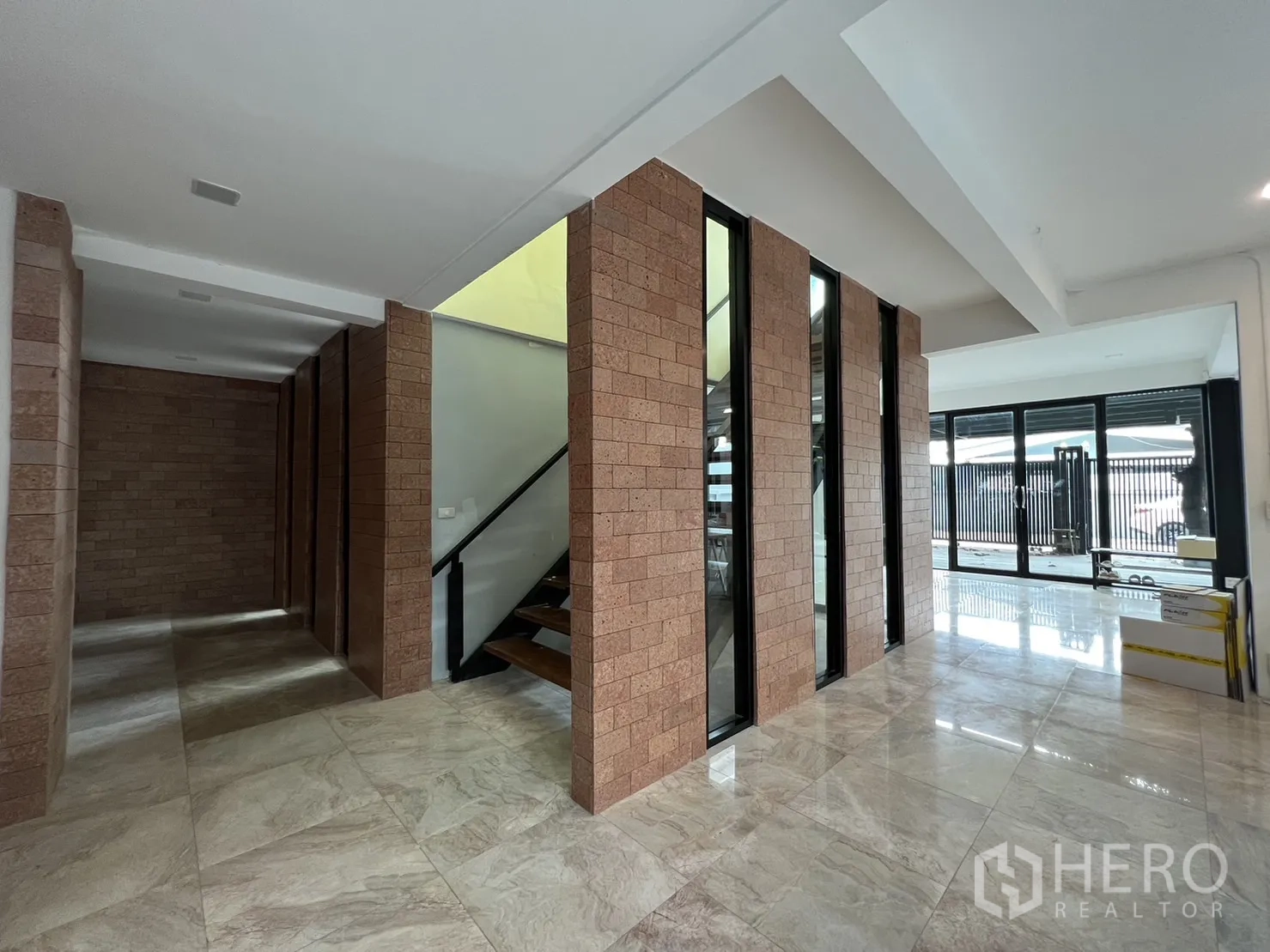 Detached House for rent or sale in Phra Khanong, Bangkok - Ground floor foyer with brick columns, large tiles and sliding doors to terrace.