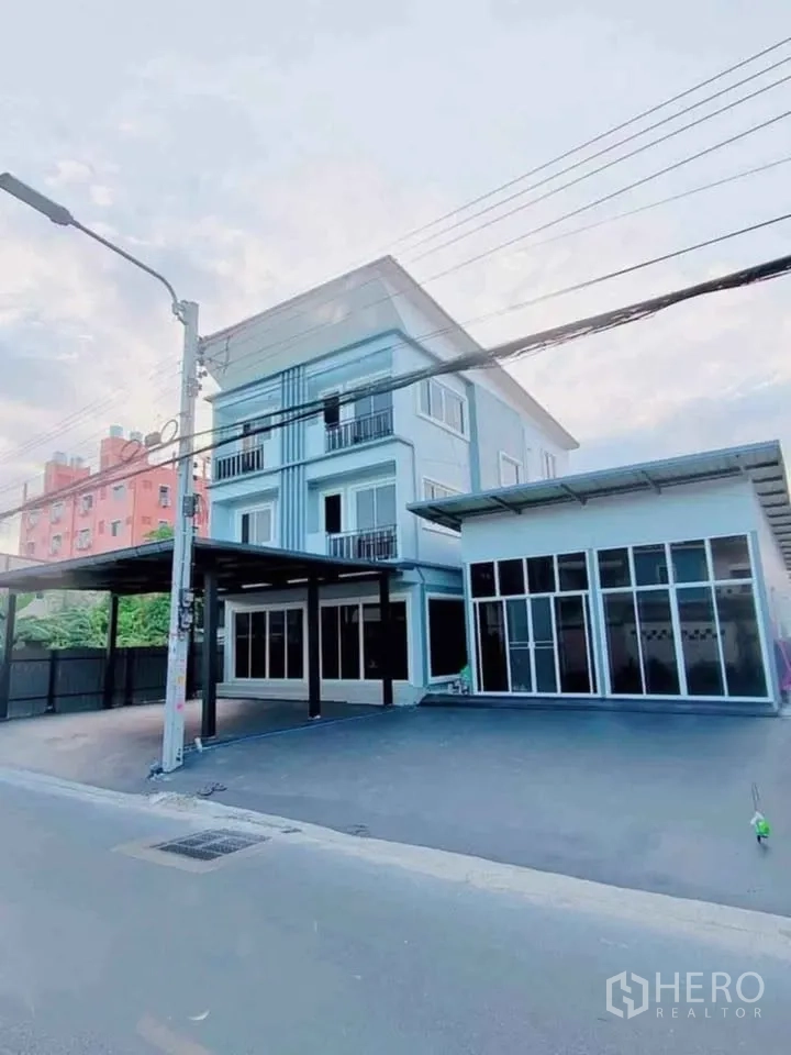 Home Office for rent in Bang Phli, Samut Prakan - Angled exterior of two combined units with wide driveway and multiple balconies.