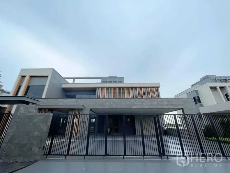 บ้าน ขายในBang Phli, Samut Prakan - ด้านหน้าบ้านเดี่ยวสไตล์โมเดิร์น พร้อมรั้วและผนังหินไม้
