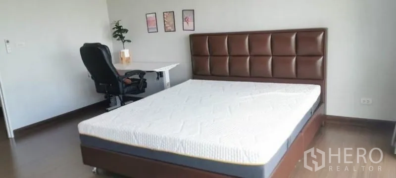 Detached House for rent - Large bedroom with padded headboard, study desk and wood floors.