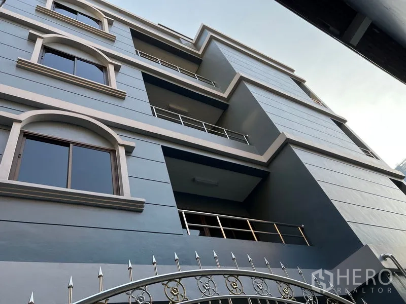 带办公室的家 出租在Pathum Wan, Bangkok - 帕吞旺现代多层家庭办公楼外立面，拱形窗与阳台清晰可见。
