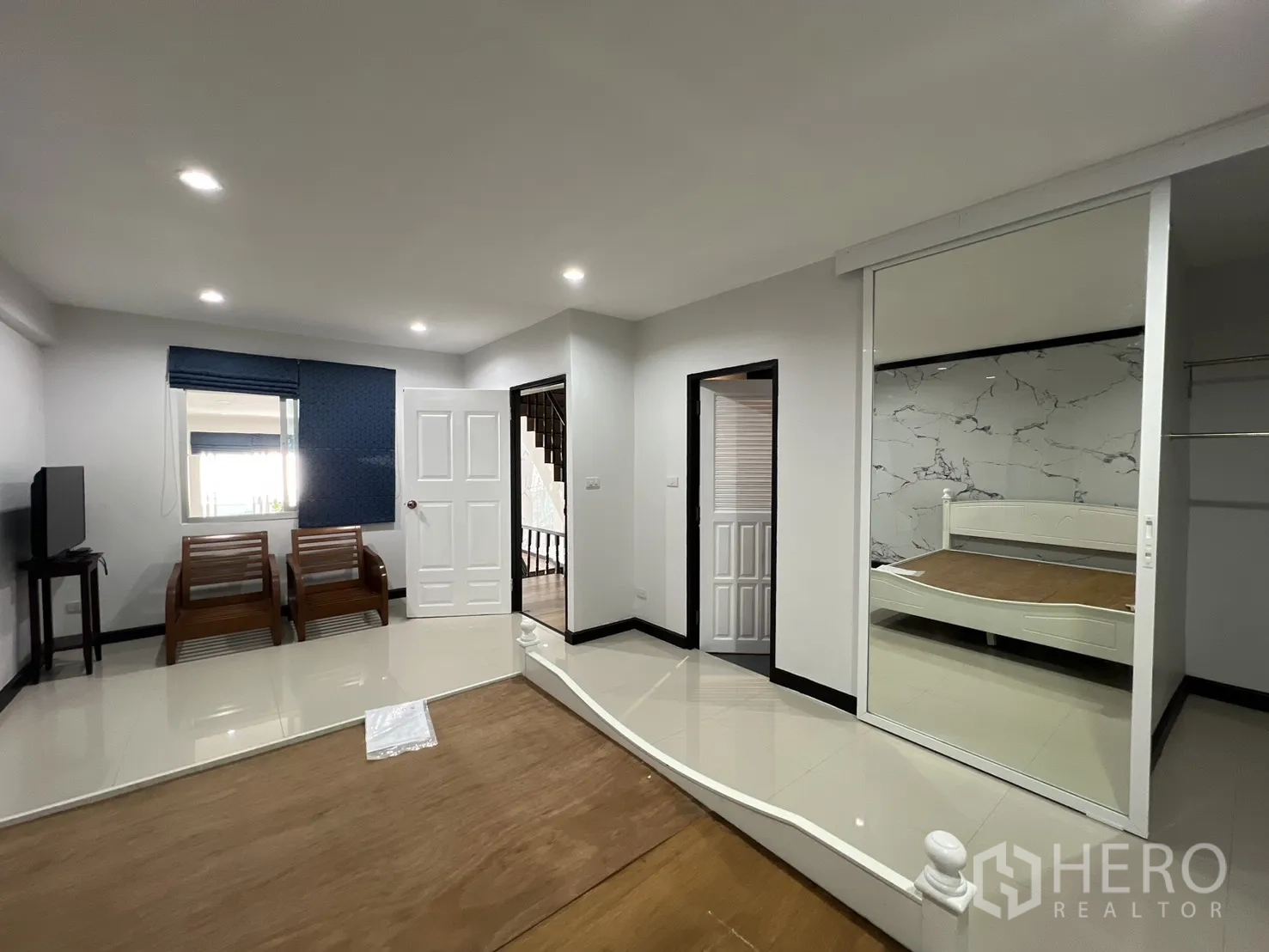 联排别墅 for rent in Watthana, Bangkok - 大套间，带休息区、电视架与镜面衣柜，旁边是床。