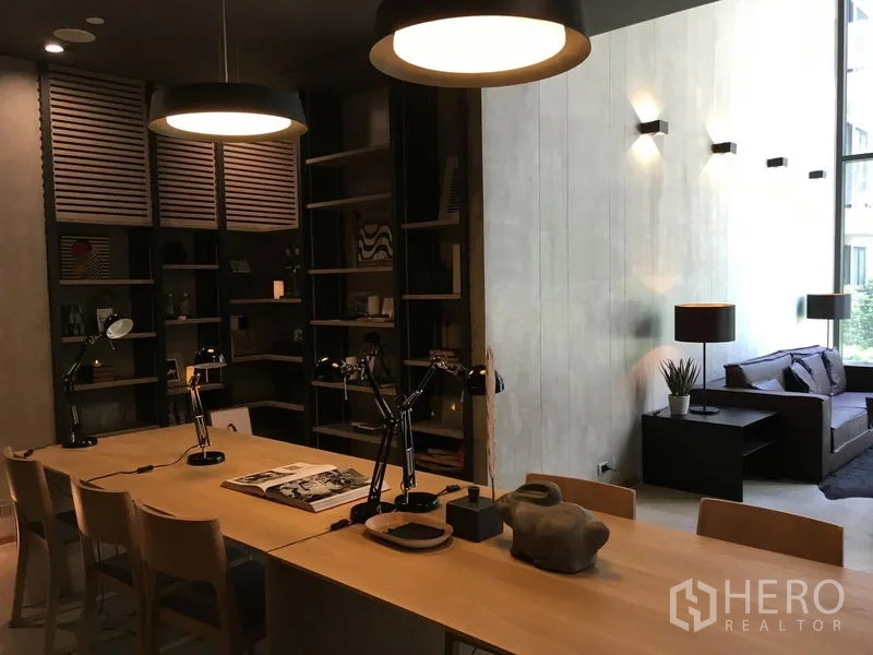 Condominium for sale in Phaya Thai, Bangkok - Co-working and library room with long table, lamps and shelving.