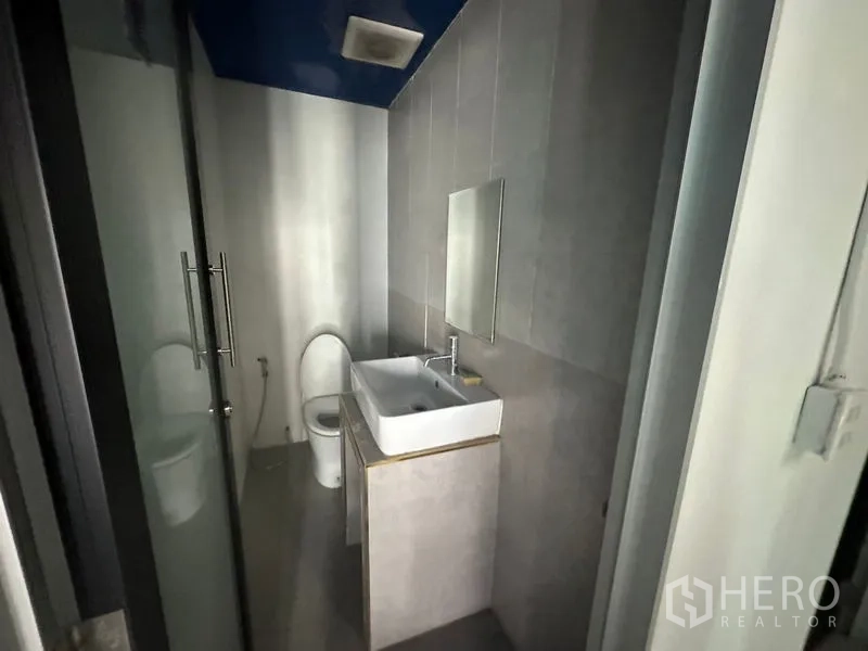 办公空间 出租在Watthana, Bangkok - 紧凑卫生间，玻璃门、盥洗台与马桶。