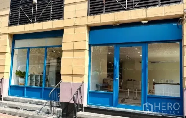 Retail Space for rent - Street-level retail frontage with wide blue-framed glass doors and display windows.