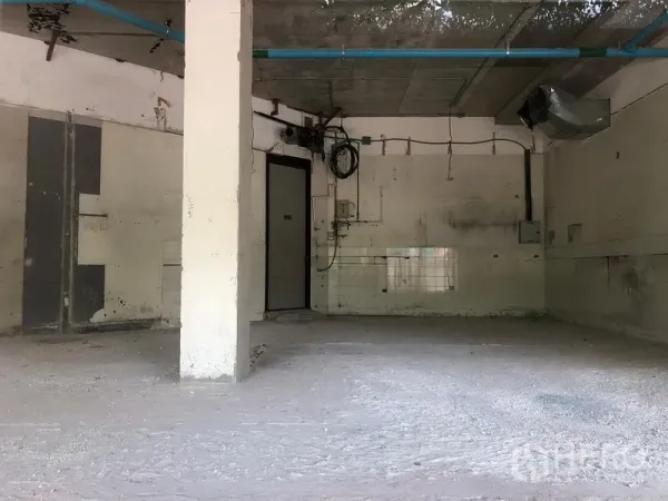 Retail Space for rent in Watthana, Bangkok - Open-plan shell space showing service lines, ductwork, and a rear access door.