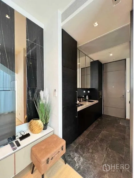 Condominium for rent - Kitchenette by the entrance with dark cabinets, stone flooring and built-in sink.