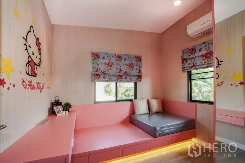独立式住宅 出租或出售在Lat Krabang, Bangkok - 儿童卧室配粉色定制柜体、平台床、柔和灯光与卡通墙饰。