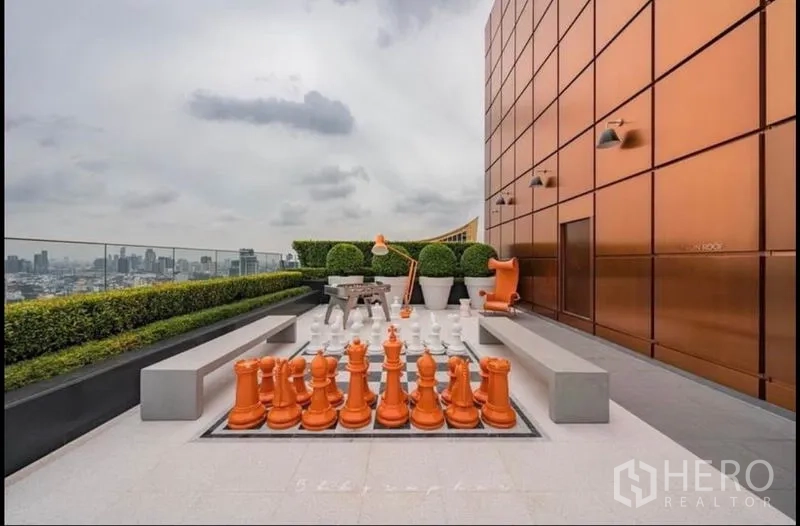 Condominium for rent or sale in Watthana, Bangkok - Rooftop garden with a giant chess set and wide city views.