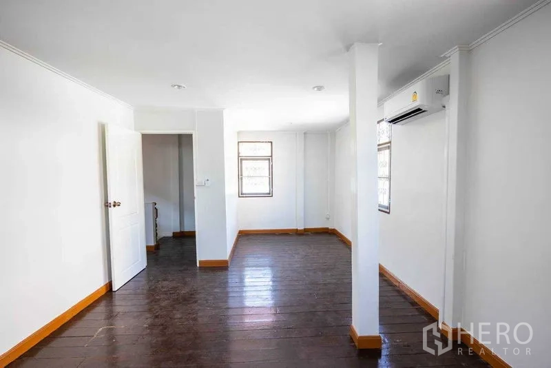 带办公室的家 出租在Watthana, Bangkok - 二层房间，深色木地板、白墙与壁挂空调，灵活可用。