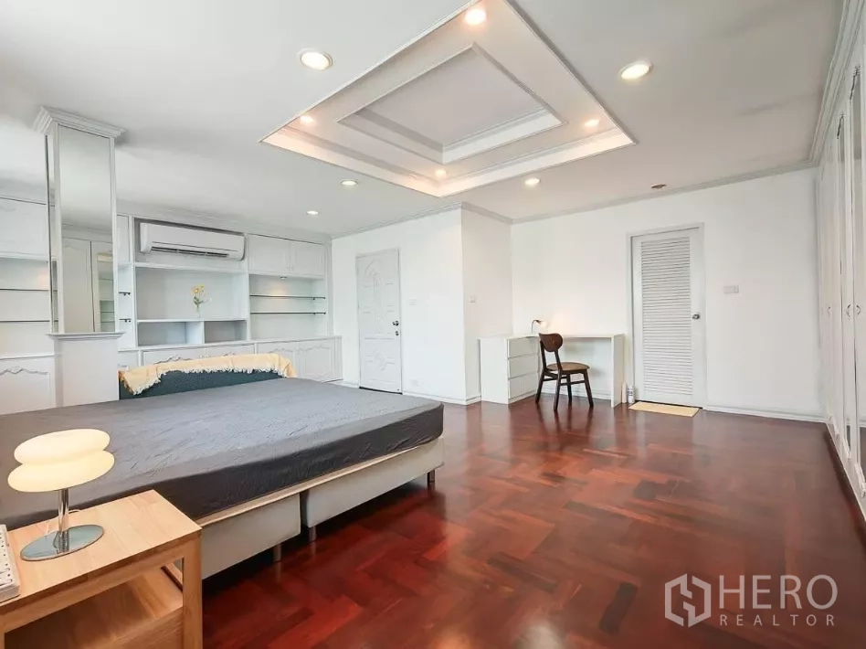 Detached House for rent in Yan Nawa, Bangkok - Expansive bedroom with built‑in shelves, work desk, and recessed ceiling lighting.