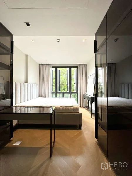 公寓 出租在Watthana, Bangkok - 采光充足的卧室，软包床头、大窗与绿意景观。