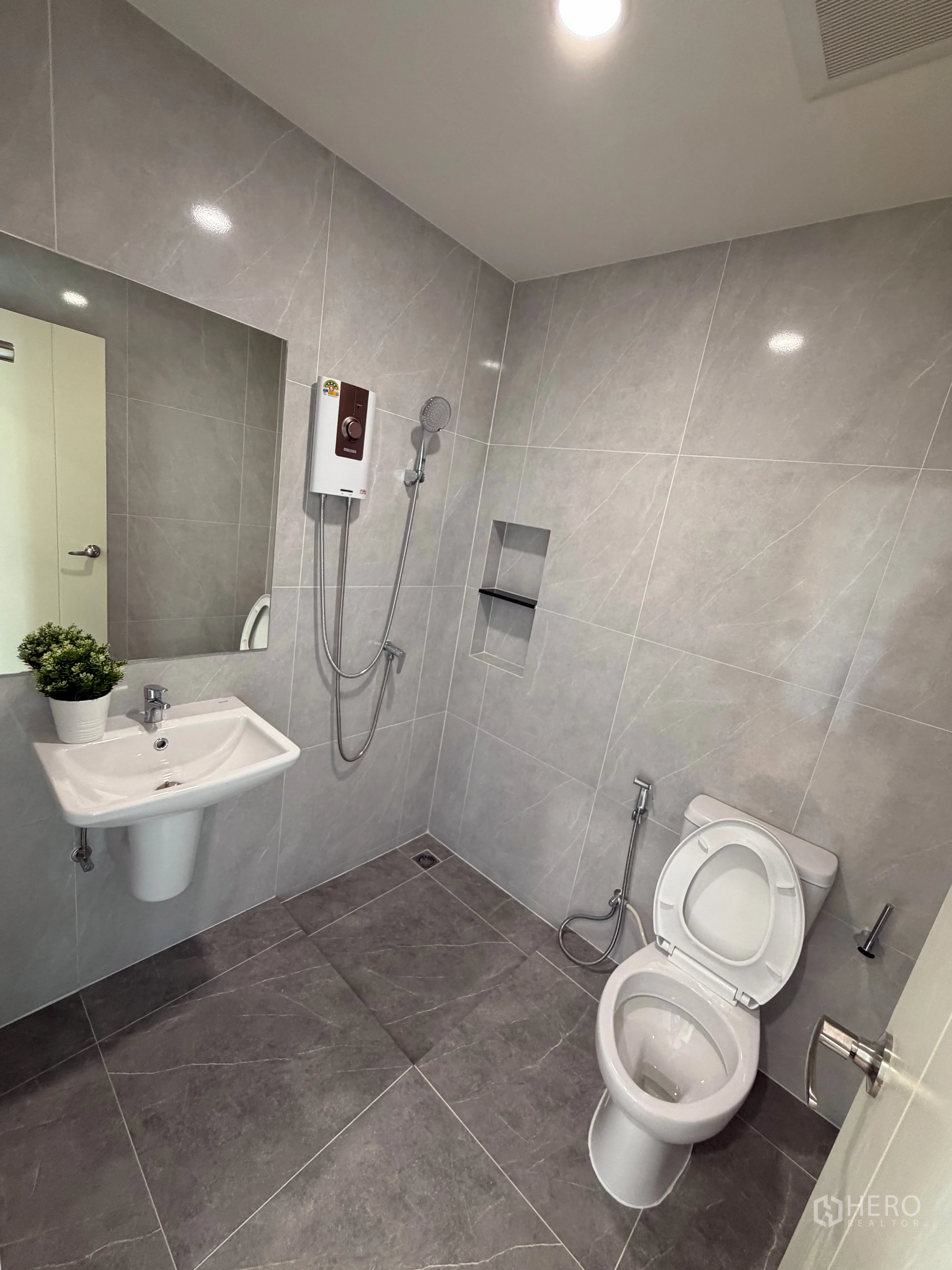 Townhouse for rent in Bang Phli, Samut Prakan - Contemporary bathroom with toilet, sink, handheld shower, and water heater.