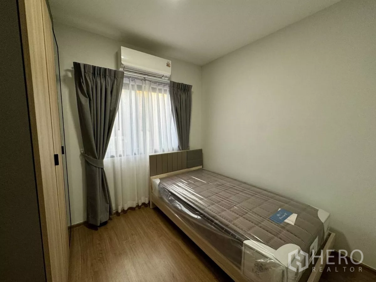 Townhouse for rent in Bang Phli, Samut Prakan - Small bedroom with single bed, grey curtains and wood wardrobe