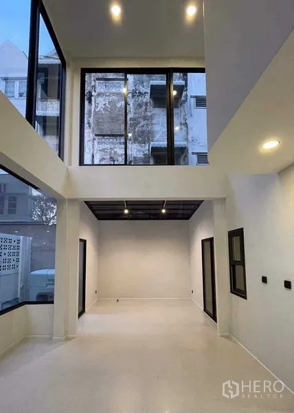 带办公室的家 出售在Lat Phrao, Bangkok - 挑高双层客厅，落地窗与夹层