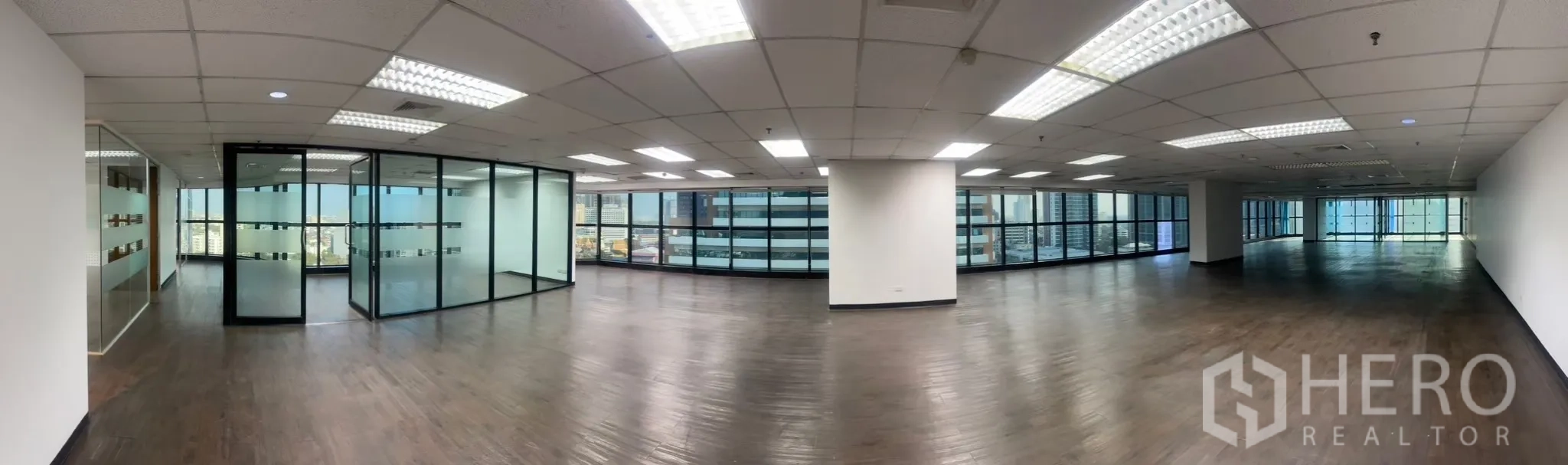 Office Space for rent in Watthana, Bangkok - Wide-angle view of expansive open office with glass partitions and skyline outlook.