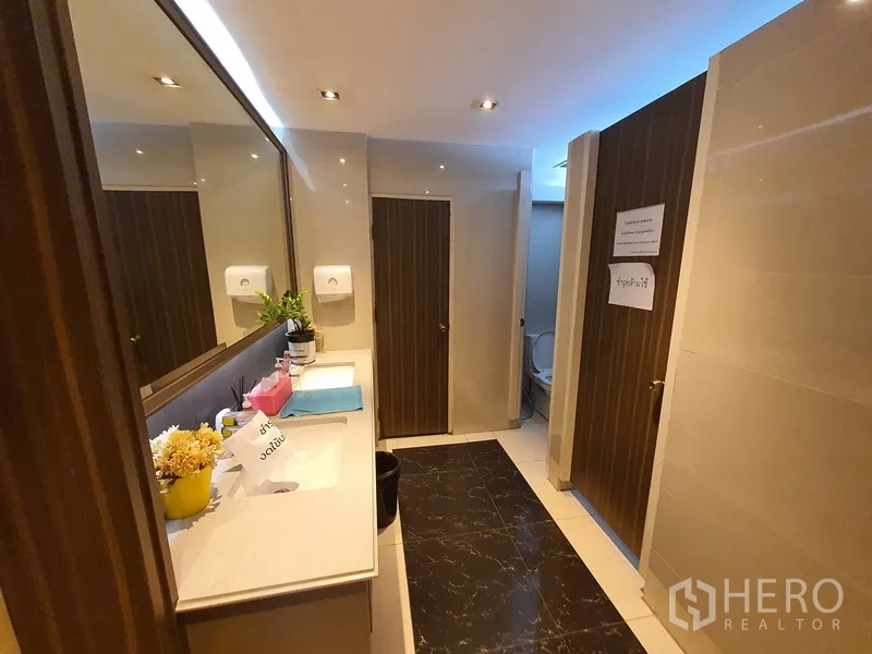 Office Space for rent in Khlong Toei, Bangkok - Modern washroom with long vanity, sinks and private stalls.