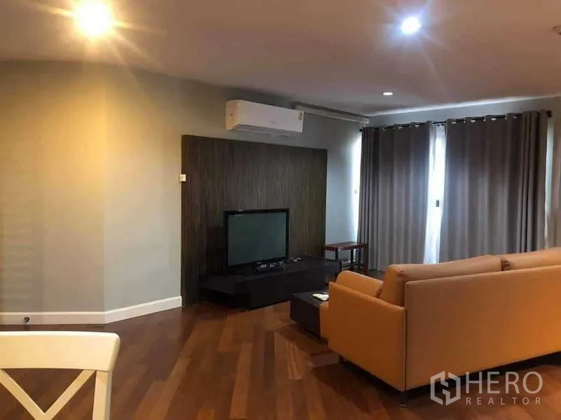 Condominium for sale in Yan Nawa, Bangkok - TV feature wall with media console, split A/C and curtained balcony doors.