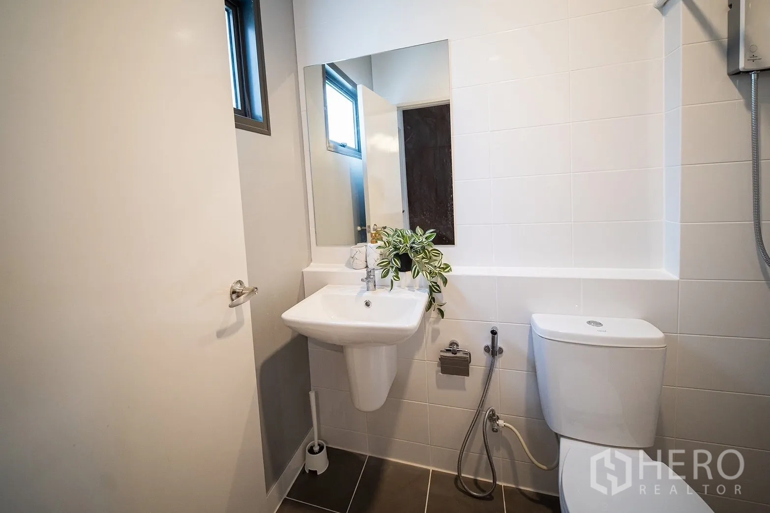 Townhouse for rent in Bang Phli, Samut Prakan - Bright bathroom with wall mirror, sink, toilet and shower.