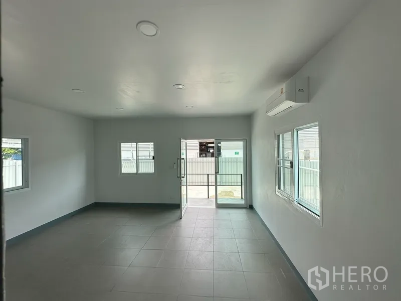 Factory for rent in Khlong Luang, Pathum Thani - Air‑conditioned office room with windows and sliding door opening to the yard.